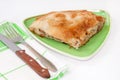 Turkish burek with meat on a green plate with fork and knife Royalty Free Stock Photo