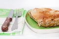 Turkish burek with meat on a green plate with fork and knife Royalty Free Stock Photo