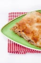 Turkish burek with meat on a green plate with fork and knife Royalty Free Stock Photo