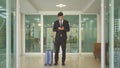 Turkish business man person with suitcase luggage walking to hall corridor and using mobile smartphone in a hotel in business trip Royalty Free Stock Photo