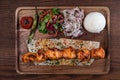 Turkish chicken sis kebab with rice and vegetables on wooden table Royalty Free Stock Photo