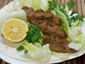 Turkish cigkofte and lemon on lettuce, lettuce, parsley, mint Royalty Free Stock Photo