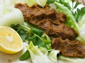 Turkish cigkofte and lemon on lettuce, lettuce, parsley, mint