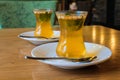 Turkish citrus tea in small cups, with the addition of pine nuts and mint leaves.