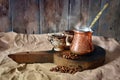 Turkish coffee background with copper coffee pot, cups and coffee beans on a wooden desk Royalty Free Stock Photo