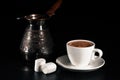 Turkish coffee, copper cezve, two marshmallows on black wood table. Closeup