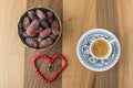 Turkish coffee, dates, and heart shaped rosary on brown table