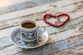 Turkish coffee and heart shaped red rosary on table