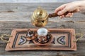Turkish coffee. Pouring Turkish coffee into vintage cup on wooden background. Pouring Turkish coffee into traditional embossed Royalty Free Stock Photo