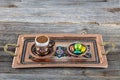 Turkish coffee. Pouring Turkish coffee into vintage cup on wooden background. Pouring Turkish coffee into traditional embossed Royalty Free Stock Photo