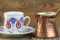 Turkish coffee with traditional ottomans motif cup and copper coffe pot Royalty Free Stock Photo