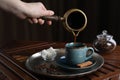 Turkish coffee. Woman pouring brewed beverage from cezve into cup at wooden table, closeup Royalty Free Stock Photo