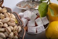 Turkish delight in iron more often with an ornament. Pistachios in a copper bowl with patterns and ornaments and two lemons. Royalty Free Stock Photo