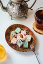 Turkish delight on a vintage plate, Moroccan teapot, honey and tea