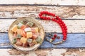 Turkish delights in plate with red rosary on vintage table