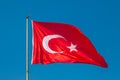 Turkish flag or flag of Turkey waving on flagpole against blue sky in Istanbul. Space for text Royalty Free Stock Photo