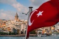 Turkish flag on a flashstock against the background of Istanbul`s neighborhoods of the Bosphorus Strait and Galata tower Royalty Free Stock Photo