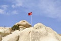 Turkish flag on the hill with tuff rock formations of the Cappadocia against the backdrop of a blue sky, Goreme, Turkey Royalty Free Stock Photo