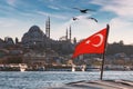 Turkish flag over Bosphorus boats, mosques, and minarets of Istanbul, Turkey. Royalty Free Stock Photo