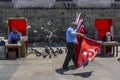 A Turkish flag seller walks past the 400 year old New Mosque in Eminonu in Istanbul in Turkey.