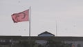 Turkish flag swaying in the wind against a clear blue sky. Action. Red flag of Turkey waving above the building and Royalty Free Stock Photo