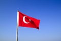 Turkish flag waving on the flagpole in the wind against the blue sky Royalty Free Stock Photo