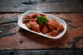 Fried aubergine or eggplant slices with tomato paste salsa sauce and cube potatoes on rustic wooden kitchen table Royalty Free Stock Photo