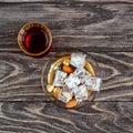 Turkish joys with different nuts is a glass of tea and a spoon. Eastern sweets. Traditional Turkish delight Rahat lokum on a Royalty Free Stock Photo