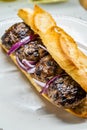 Turkish Kofte Ekmek / Meatball Sandwich with Red Onions. Traditional Fast Food from Turkey