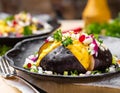 Turkish Kumpir, baked potato stuffed with cheese, bacon, salted cucumber, herbs and butter Royalty Free Stock Photo