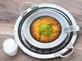 Turkish kunefe dessert in special serving dish with green pistachio