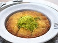 Turkish kunefe dessert in special serving dish with green pistachio