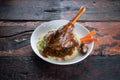 Turkish lamb shank in dark sauce with potato puree and vegetables on rustic wooden table Royalty Free Stock Photo