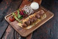 Turkish lamb sis kebab with rice and vegetables on rustic wooden table