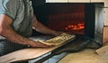 Muslim Turkish baker male putting traditional ramadan bread into the oven