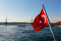 Turkish national flag fluttering on Bosphorus from ship with beautiful bridge view on background. Istanbul, Turkey Royalty Free Stock Photo