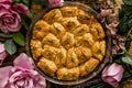 Turkish Pistachio Pastry Dessert, Baklava Presented on a Round Tray Surrounded by Roses