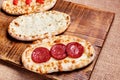 Turkish pita bread on a wooden cutting board. Mini pizzas Royalty Free Stock Photo