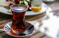 Turkish red aromatic tea in traditional authentic glass cup - armudu on table close-up Royalty Free Stock Photo
