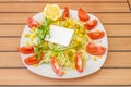 Turkish salad with fresh square cheese, sweet corn, iceberg lettuce with lots of tomato wedges, pitted Spanish olives and a sprig Royalty Free Stock Photo