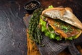 Turkish Street Food Balik Ekmek, fish sandwich with grilled mackerel fillet in a bun. Dark background. Top view. Copy Royalty Free Stock Photo