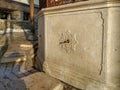 Turkish style architecture outside water faucet in stone with carvings on a sunny day