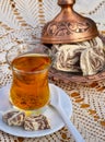 Turkish tea in a glass Cup and marble halva on a table with a handmade tablecloth and candy maker on a Sunny day Royalty Free Stock Photo