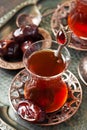 Turkish tea in traditional glass with sweet dates Royalty Free Stock Photo