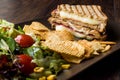 Turkish Toast or Tost / Triangle Club Sandwich with Melted Cheese, Ham and Served with Chips and Salad. Royalty Free Stock Photo