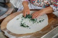 Turkish woman prepares Gozleme - traditional dish in the form of flatbread stuffed with greens and cheese