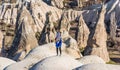 A Turkish woman wearing stripped hijab standing on the top of the sandrock, looking at the vocanic rocks in the park, Goreme, Royalty Free Stock Photo