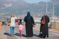 Turkish women in national dress and a little girl walking along the embankment