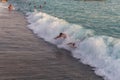 People swim in the sea and dive after the wave. People rejoice in the waves. Holidays in Turkey.