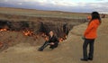 Turkmenistan, Darvaza - March 21, 2019: Girls make a photo on the background of the burning crater